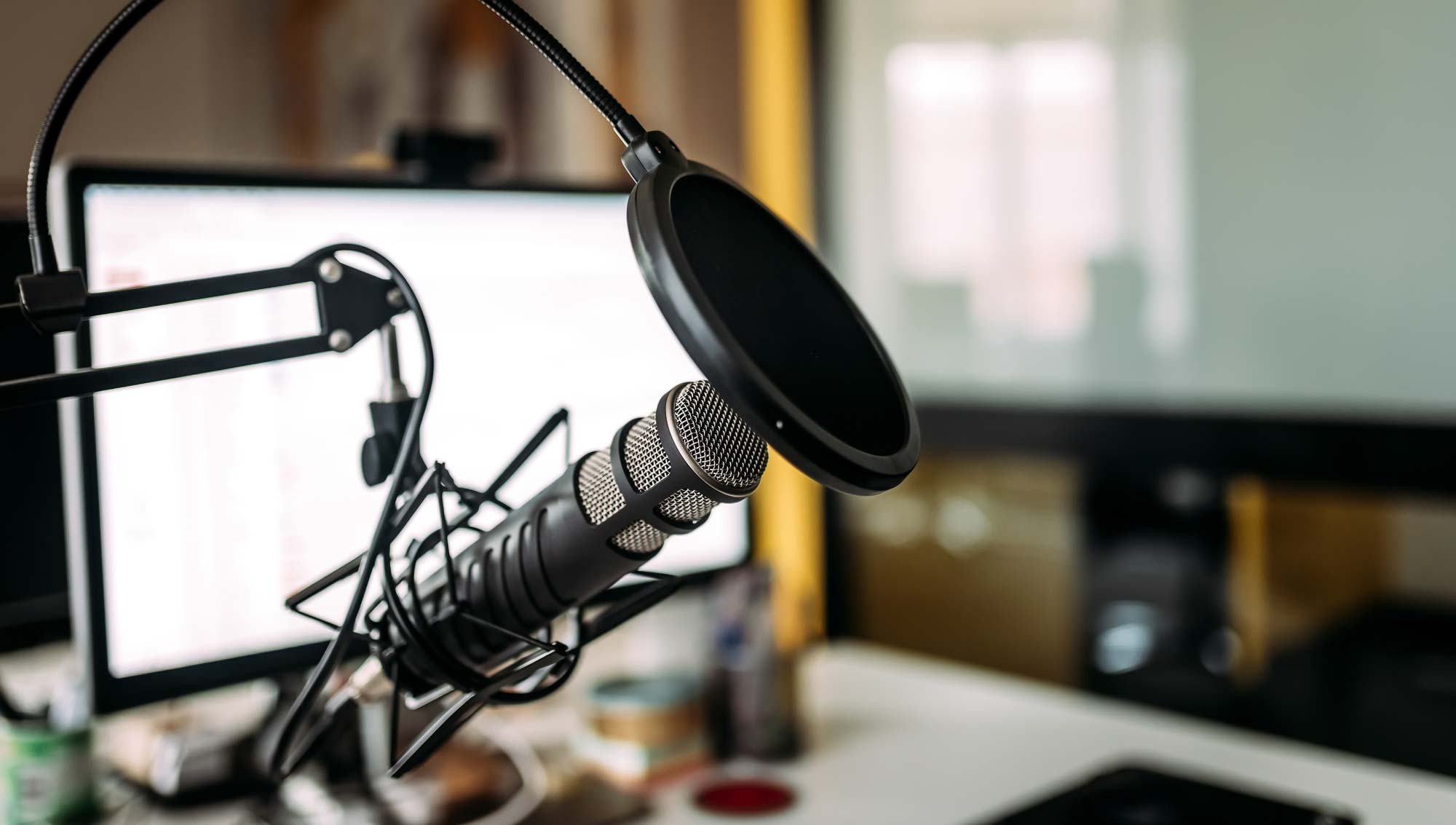 Image of a podcast mic in front of computer